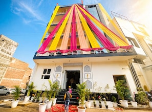 A multi-story building with a balcony decorated with colorful drapes. - The Swarnim Hotel, Sector 48 Noida (Noida)
