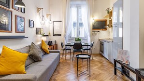 Eine moderne Wohnung mit Essbereich, Küche und einem Sofa mit gelben Kissen.