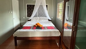 Un dormitorio con cama con dosel, un armario y una ventana con barrotes.