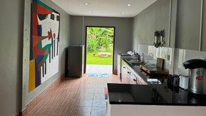 Una cocina moderna con un ventanal grande, un refrigerador y una encimera con diversos electrodomésticos.