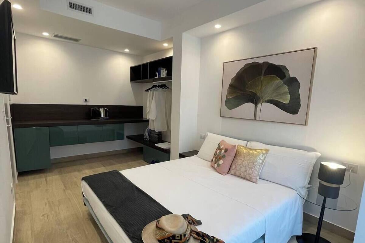 Une chambre moderne avec un grand lit, une table de chevet, une armoire et une salle de bain.