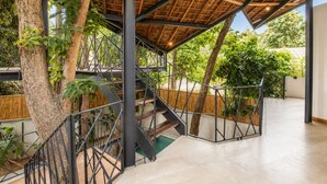 A modern staircase with metal railings, a wooden ceiling, and a view of greenery outside. - Designer 2-BR Villa Pool, 800m to Canggu Beach (Kecamatan Mengwi)