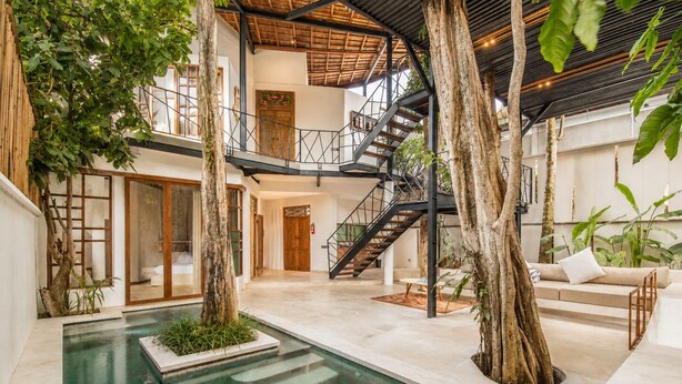 A modern indoor pool area with a staircase, seating, and trees. - Designer 2-BR Villa Pool, 800m to Canggu Beach (Kecamatan Mengwi)