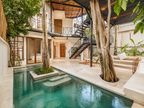 A modern indoor pool area with a staircase, seating, and trees. - Stylish 2-BR Villa with Pool, 800m Canggu Beach (Kecamatan Mengwi)