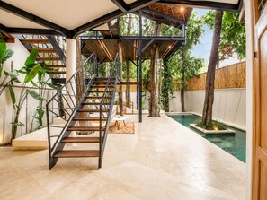 A modern interior with a staircase, indoor pool, and lush greenery. - Chic 2-BR Villa with Pool, 800m to Canggu Beach (Kecamatan Mengwi)