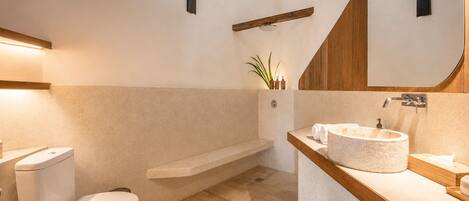 A modern bathroom with a toilet, a bathtub, and a vanity with a sink.