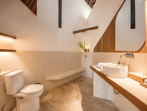 Un baño con inodoro, bañera, lavabo y espejo.