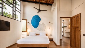 A bedroom with a bed, a ceiling fan, a TV, and a large window with plants. - Luxurious 1-BR Villa with Pool, Echo Beach 800m (Kecamatan Mengwi)