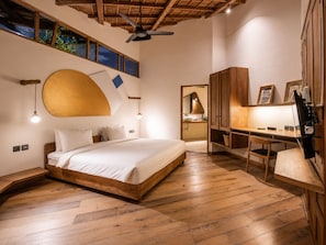 Un dormitorio con cama de madera, un escritorio y un ventilador de techo.