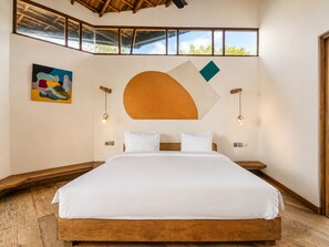 Une chambre à coucher avec un grand lit, une tête de lit en bois et un puits de lumière.