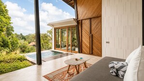 A modern outdoor living area with a pool, a covered seating area, and a view of the surrounding greenery. - Stunning 2-BR Penthouse with view 800m to beach (Kecamatan Mengwi)