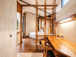 Une chambre moderne avec un bureau en bois, un lit et une vue sur l’extérieur.