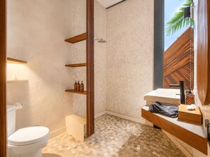 Et moderne badeværelse med toilet, brusebad og håndvask.