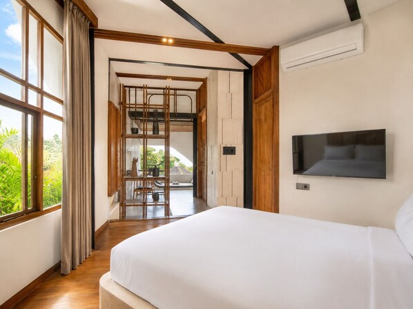 Une chambre avec un grand lit, un téléviseur fixé au mur et une vue sur la verdure.
