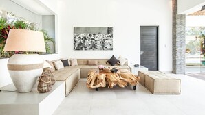 A modern living room with a sectional sofa, a coffee table with a natural wood centerpiece, and a large floor lamp.
