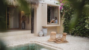 A pool area with a glass-enclosed window, wicker furniture, and a thatched roof. - Serene 3BR Villa, Stylish Interiors, beach close (Uluwatu)
