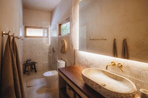 A bathroom with a wooden vanity, a large mirror, a stone sink, and a toilet. - Serene 3BR Villa, Stylish Interiors, beach close (Uluwatu)