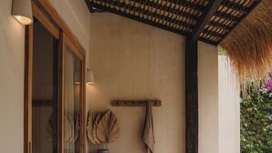 A cozy patio area with a thatched roof, a cushioned seating area, a wooden table, and a large vase. - Serene 3BR Villa, Stylish Interiors, beach close (Uluwatu)