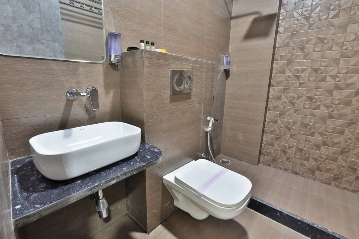 A bathroom with a white sink, a toilet, and a shower.