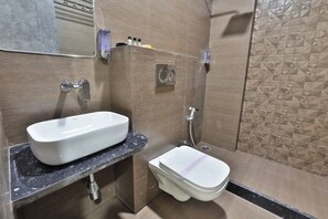 Un baño con lavamanos blanco, inodoro y ducha.
