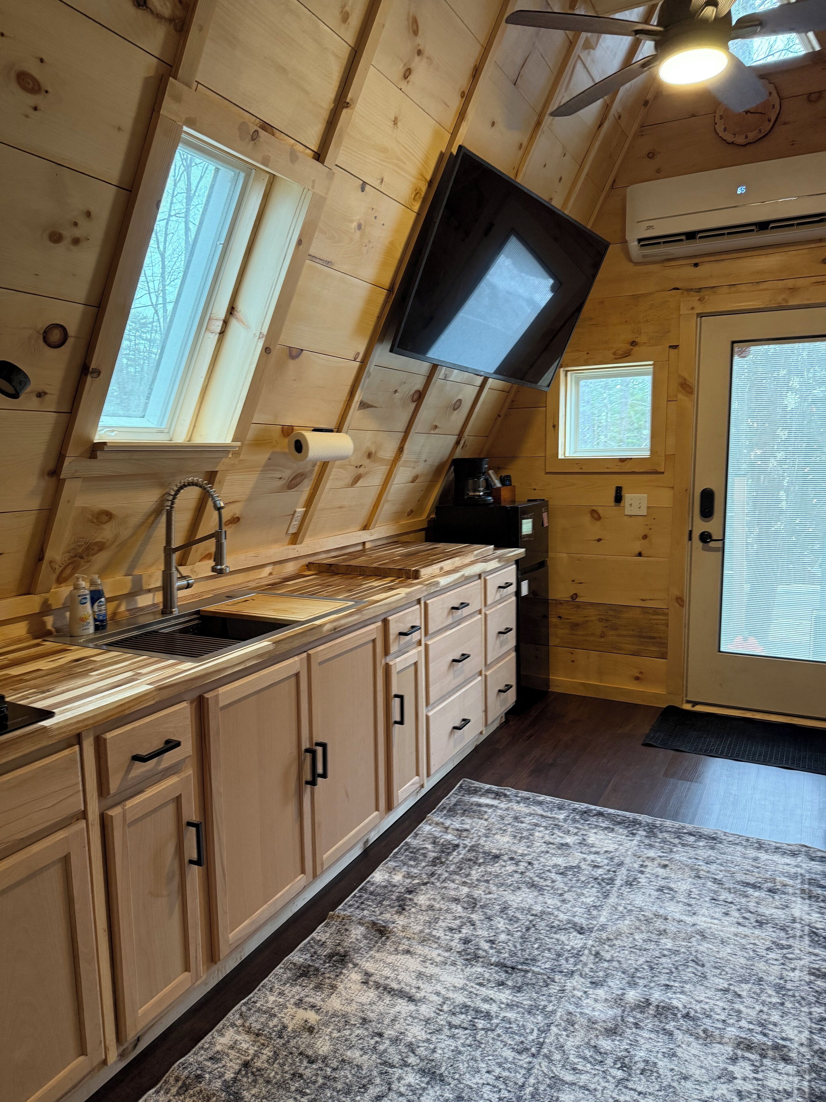 A kitchen with wooden cabinets, a sink, and a window.