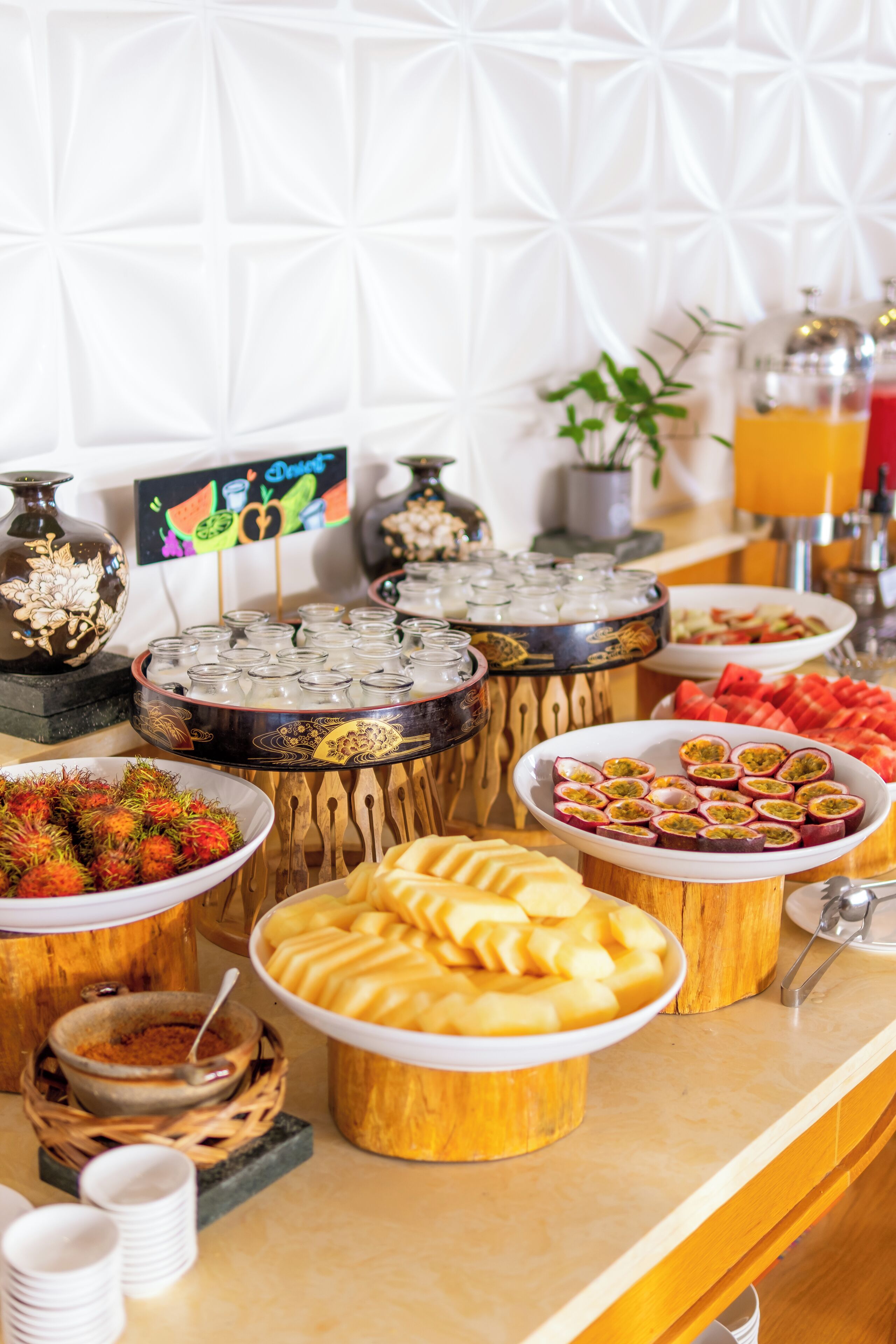 A buffet with various food items and beverages, including fruits, pastries, and a selection of drinks.