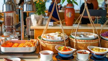 A buffet with various dishes and condiments.