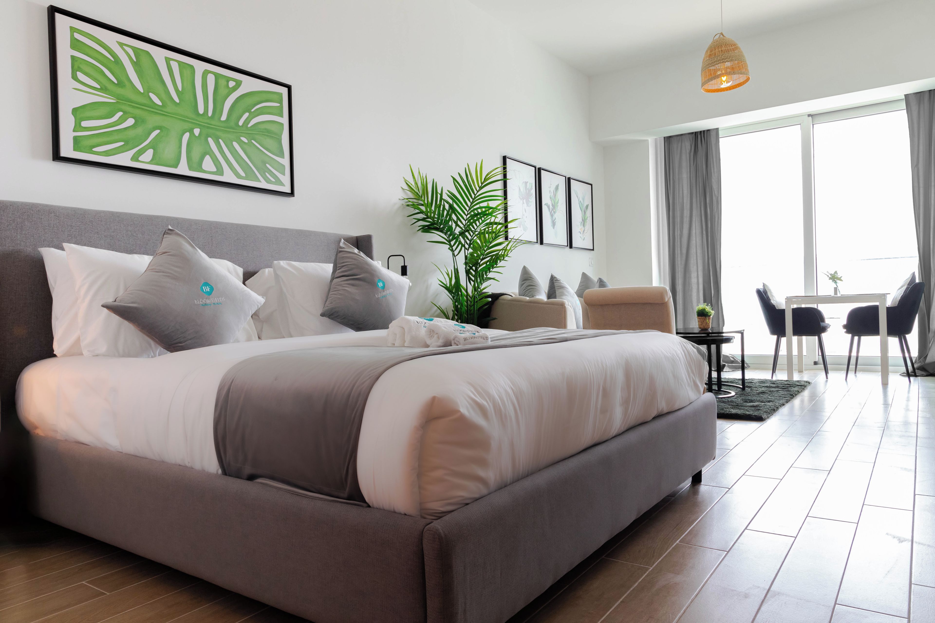 Una habitación de hotel moderna con una cama grande, un escritorio y vistas al exterior.