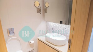 Ein Badezimmer mit Toilette, Waschbecken und Spiegel.
