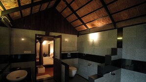 A modern bathroom with a wooden ceiling, a large mirror, a sink, and a toilet.