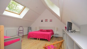 A bedroom with a bed, a desk, a chair, a radiator, and a skylight. - "Les Genêts" your charming gîte in Essonne (Buno-Bonnevaux)