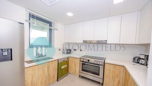 Una cocina moderna con armarios blancos, un horno Bosch y un lavavajillas.