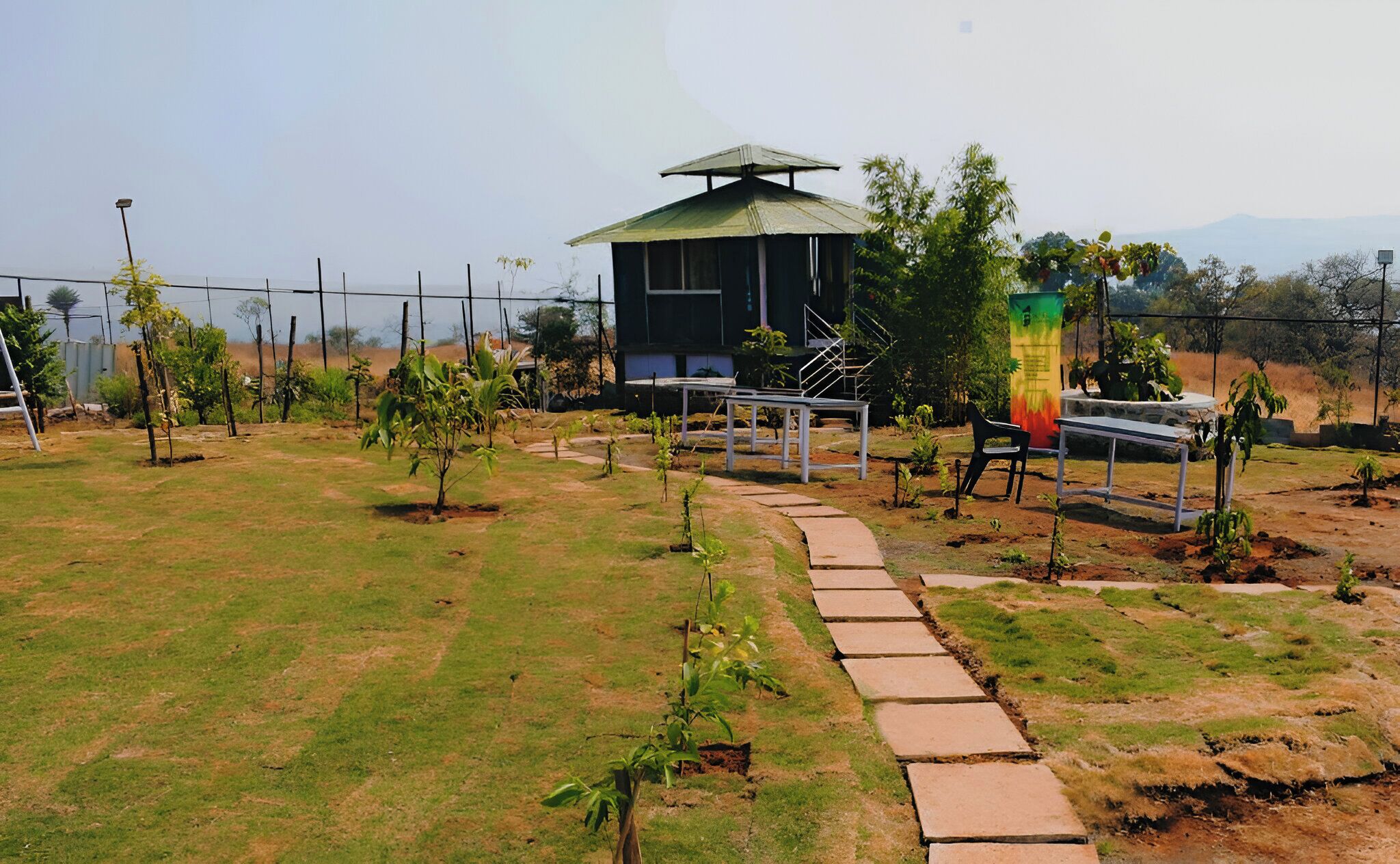 A garden with a pathway leading to a building with a green roof.