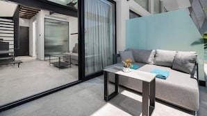 Un salon moderne avec un canapé, une table basse et une cloison en verre.