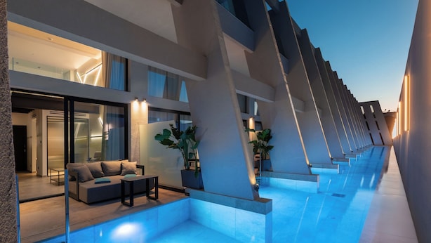Un hôtel moderne doté d’une piscine, d’un espace extérieur aménagé et d’un design contemporain.