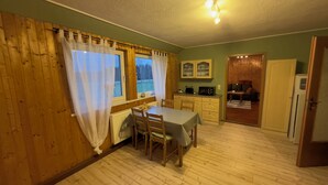 A cozy room with wooden walls and a dining table set for two. - Cozy vacation apartment in an idyllic natural location (Rosenthal-Bielatal)