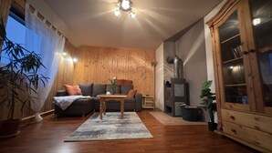 A cozy living room with a sofa, coffee table, and a fireplace. - Cozy vacation apartment in an idyllic natural location (Rosenthal-Bielatal)