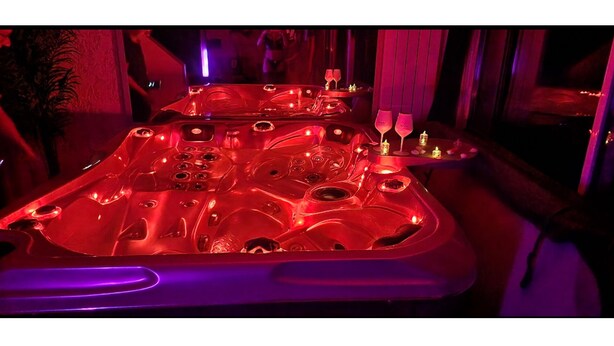 A hot tub with multiple jets, surrounded by candles and glasses, in a dimly lit room. - Furnished duplex Xcoquine Spa & pool (Tourves)