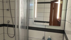 A bathroom with a shower, sink, and mirror. - Your haven of peace near Hamburg Airport (Quickborn)