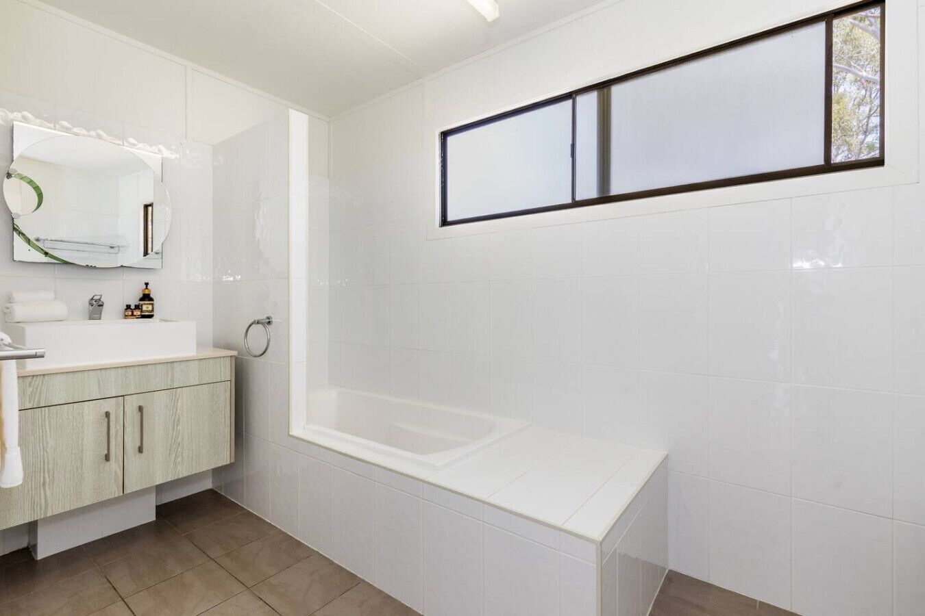 Ein modernes Badezimmer mit Waschbecken, Spiegel und Badewanne.