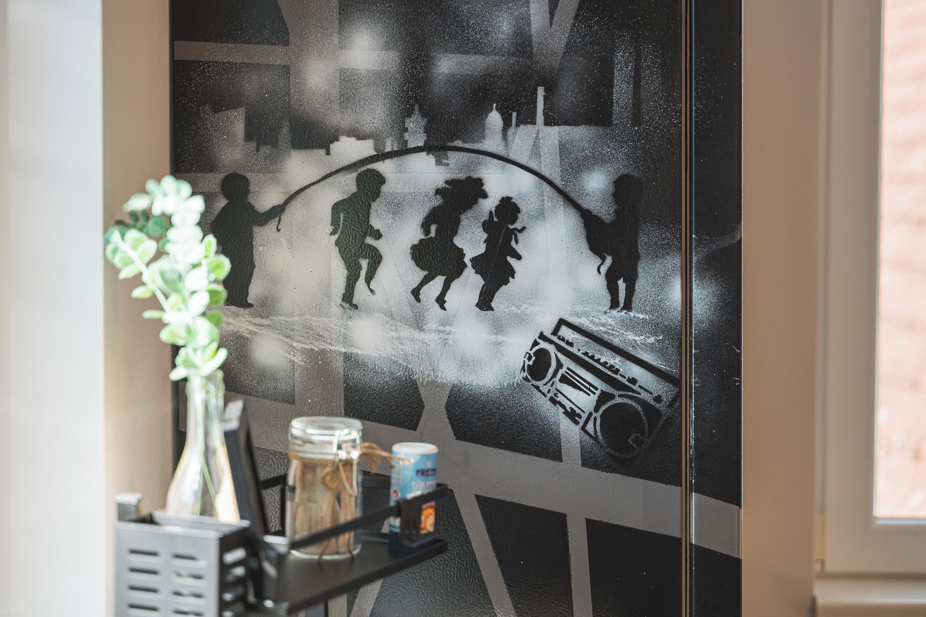 A wall with a silhouette mural of people and a radio.