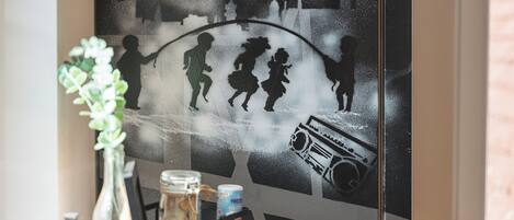 A wall with a silhouette mural of people and a radio.