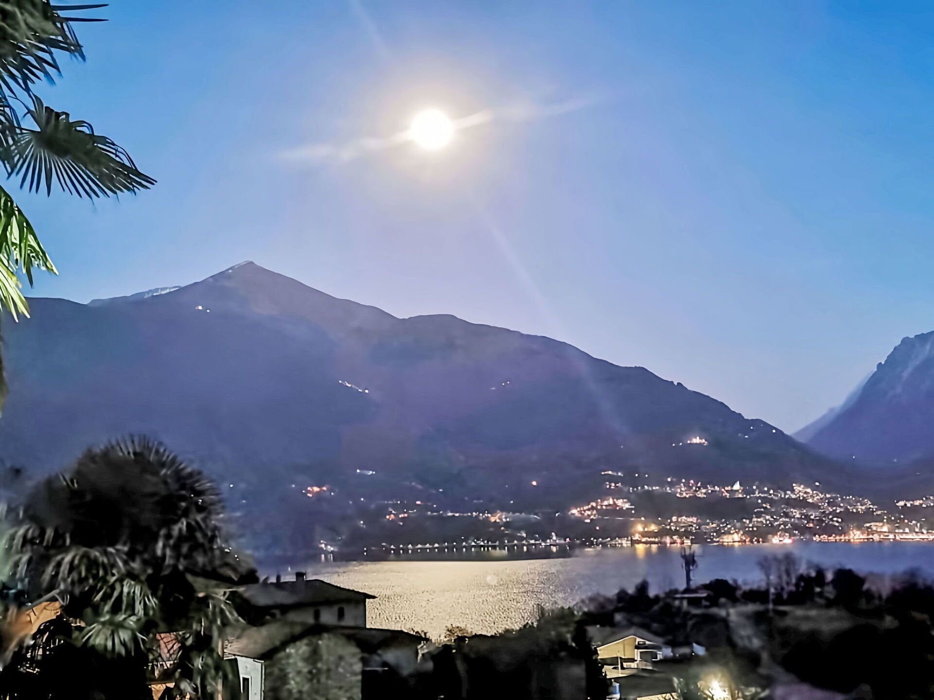 A mountain landscape with a body of water and a town in the background.