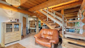 A rustic interior with a leather sofa, wooden staircase, and a wooden cabinet. - Stunning private villa for 12 guests with WIFI and patio (Dluhoště)