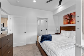 A bedroom with a bed, a nightstand, a painting, and a dresser. - Zion Cliffside Retreat l Gem for Relaxation (Hurricane)
