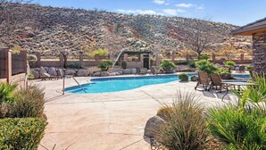 Un jardin avec une piscine, des chaises longues et une pergola.