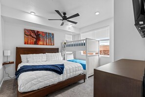 A bedroom with a wooden bed, a ceiling fan, a window with blinds, and a painting on the wall. - Zion Cliffside Retreat l Gem for Relaxation (Hurricane)