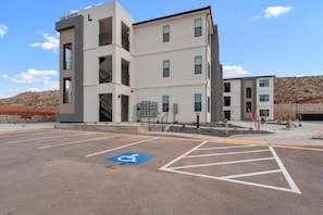 A multi-story building with a parking lot in front, including a handicapped parking space. - Zion Cliffside Retreat l Gem for Relaxation (Hurricane)