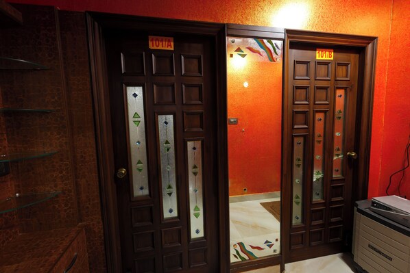 Two wooden doors with frosted glass panels and a sign above each door. - SBHS Homestay - Neeladri  (Tirupati)
