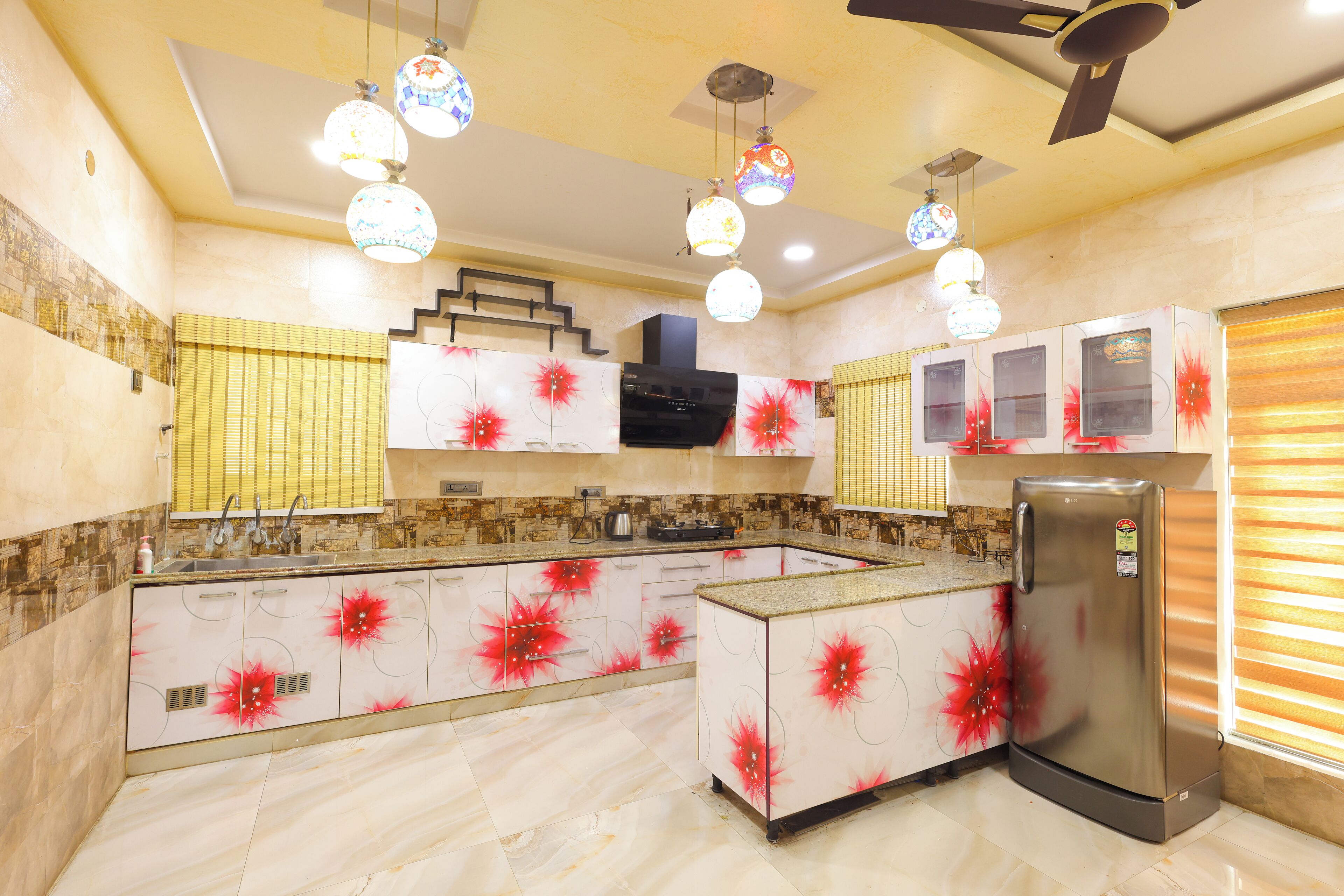 Una cocina con isla central, electrodomésticos integrados e iluminación decorativa.